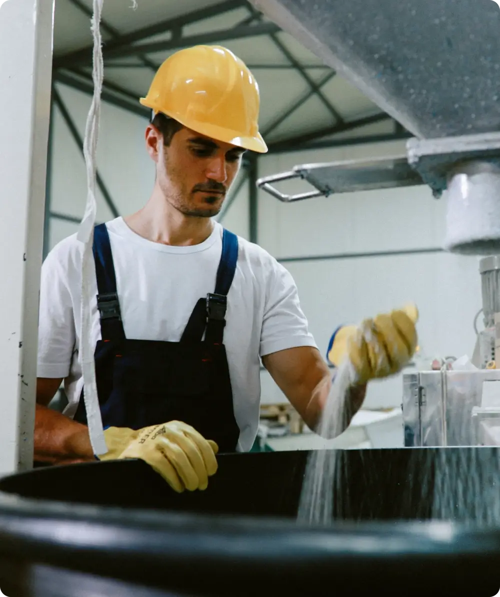 Worker operating machinery in industrial setting.