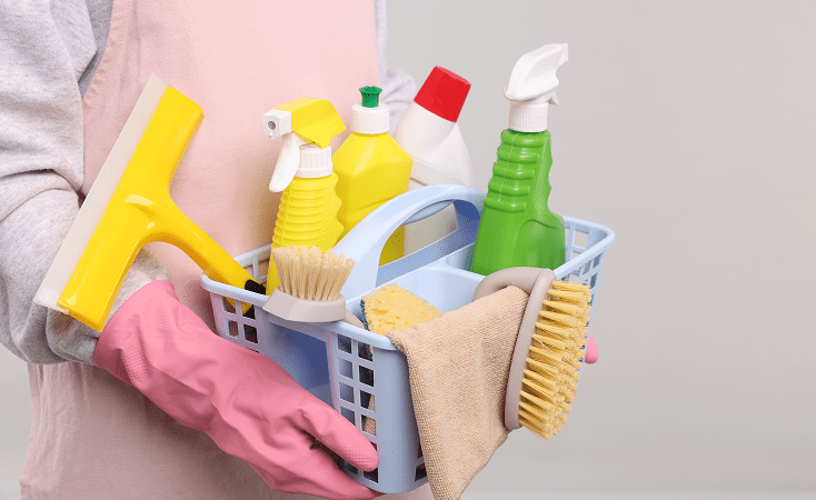 Basket with various cleaning supplies and tools for household chores.