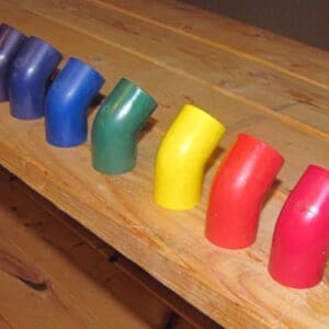 Colorful wooden toy pieces arranged in a row on a wooden surface.