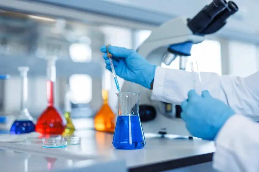 Scientist mixing blue liquid in laboratory.