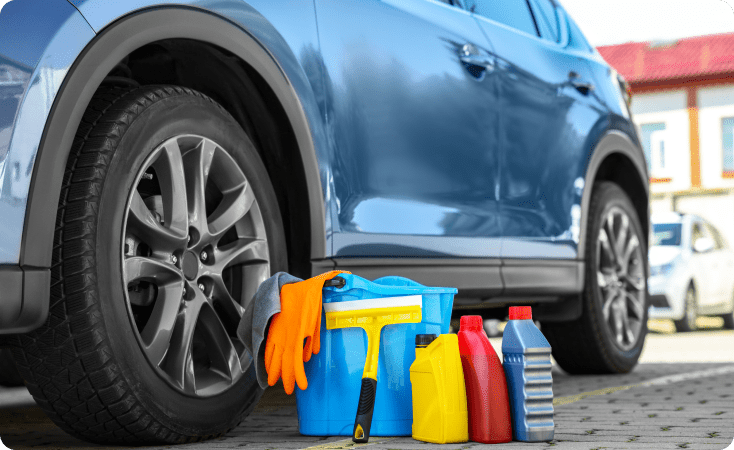 Car cleaning supplies next to a blue vehicle.